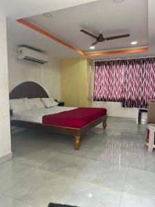 a bedroom with a large bed with a red blanket at Srilakshmi Residency in Tirupati
