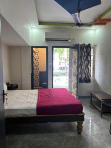 a bedroom with a large bed and a window at Srilakshmi Residency in Tirupati +4 photos
