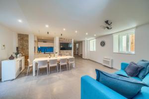 a living room with a blue couch and a kitchen at Villa Majestic with heated pool and rooftop terrace in Bol