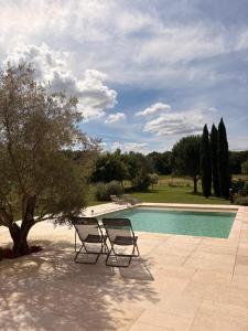 two chairs sitting in front of a swimming pool at Communay Gablys Chambres in Communay