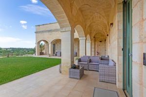 an outdoor patio with chairs and an archway at TENUTA DOROLIVO in Otranto