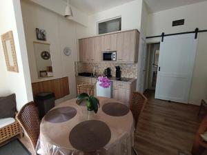 a kitchen with a table and chairs in a room at Céhmesterek apartman in Eger
