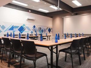 a conference room with a long table with chairs and blue bottles at ibis Barranquilla in Barranquilla