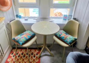 a table and three chairs in a small kitchen at Cosy Seaside Snug in Helensburgh