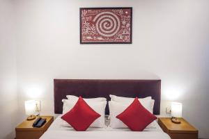 a bed with two red pillows and a picture on the wall at Hotel Paradise in Chākan