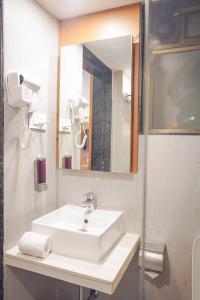 a bathroom with a white sink and a mirror at Hotel Paradise in Chākan