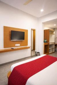 a bedroom with a bed with a tv on the wall at Hotel Paradise in Chākan