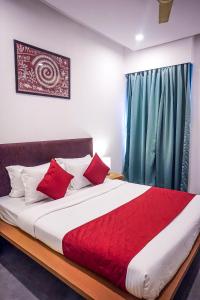 a bedroom with a large bed with red pillows at Hotel Paradise in Chākan +6 photos
