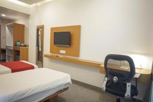 a hospital room with a bed and a desk with a tv at Hotel Paradise in Chākan