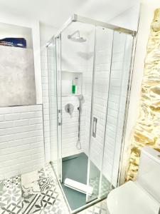 a shower with a glass door in a bathroom at El Rincón de Salsipuedes in Cudillero