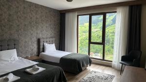 a hotel room with two beds and a window at Alya Teras Otel in Trabzon