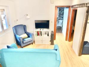 a living room with a blue couch and a tv at El Rincón de Salsipuedes in Cudillero