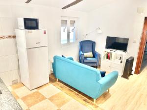 a living room with a blue couch and a tv at El Rincón de Salsipuedes in Cudillero +26 photos
