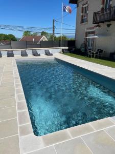 a swimming pool with blue water in front of a house at Ecolodge Insolite in La Bâtie-Montgascon