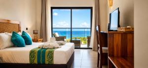 a bedroom with a bed with a view of the ocean at Le Marin, Rodrigues Island in Rodrigues Island