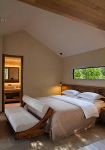 a bedroom with a large bed and a chair at Dali Jiwu Hotel in Dali