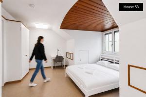 a woman walking through a bedroom with a bed at Sigma Self Check-in Hostel in Zurich