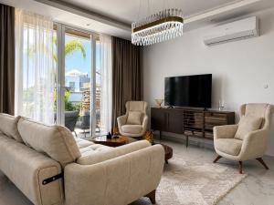 a living room with a couch and two chairs and a tv at Nothern Cyprus Four Seasons Life Collection Apartments & Lofts Seafront in Ayios Dhometios
