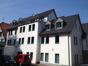 um edifício branco com um telhado preto em Hotel Am Schlosstor em Buckeburgo