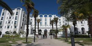 a large white building with palm trees in front of it at Gîte de Famille avec Jacuzzi, location longue ok in Candresse