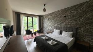 a bedroom with a bed and a stone wall at Alya Teras Otel in Trabzon