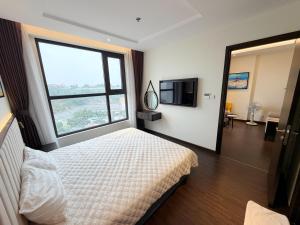 a bedroom with a bed and a large window at The Sapphire Hòn Gai Apartment - Trung tâm Hạ Long in Ha Long