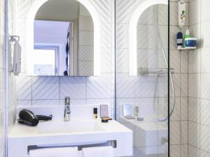 a white bathroom with a sink and a shower at ibis Styles Sceaux Paris Sud in Sceaux +34 photos