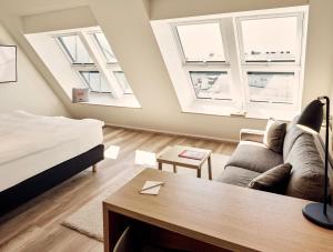 a living room with a couch and two windows at Schwabinger Wahrheit by Geisel in Munich +73 photos
