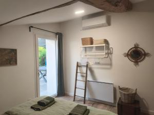 a room with a bed and a ladder and a window at Gîte de Famille avec Jacuzzi, location longue ok in Candresse