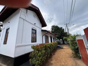 a white house with some plants in front of it at Radiance Inn in Jaffna
