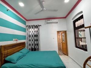 a bedroom with a bed with blue and white stripes at Radiance Inn in Jaffna +3 photos