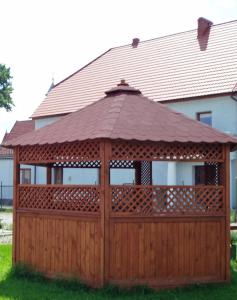 a wooden gazebo with a wooden fence at Pokoje u Doroty in Kurowice