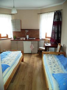two beds in a room with a kitchen and a kitchen at Pokoje u Doroty in Kurowice