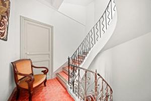 a staircase with a wooden chair and a stair case at Escapade elegante dans un ecrin d histoire in Hyères