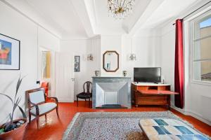 a living room with a fireplace and a television at Escapade elegante dans un ecrin d histoire in Hyères