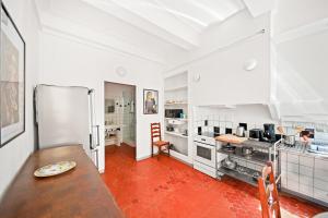 a large kitchen with a table and a refrigerator at Escapade elegante dans un ecrin d histoire in Hyères +4 photos