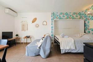 a bedroom with two beds and a couch and a tv at A deux pas de la plage de sable in Le Pradet