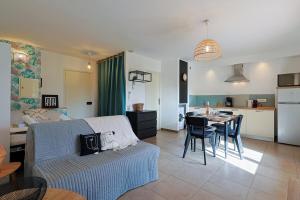 a living room and kitchen with a couch and a table at A deux pas de la plage de sable in Le Pradet