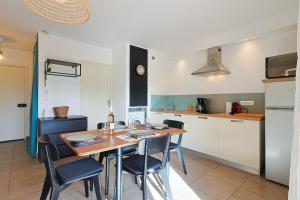 a kitchen with a table and chairs in a room at A deux pas de la plage de sable in Le Pradet +13 photos