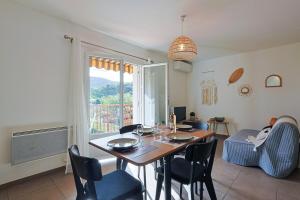 a dining room with a table and chairs and a window at A deux pas de la plage de sable in Le Pradet
