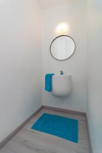 a bathroom with a mirror and a blue rug at Bonaire Bay View Villa in Kralendijk