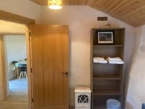 a room with a door and a shelf with towels at The Thatched Cottage in Cork