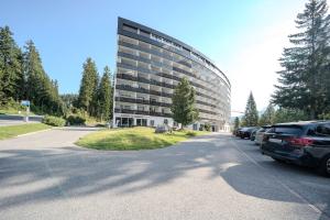 a parking lot in front of a large building at Alexandra 120 by Arosa Vacations, Renoviertes Studio mit Bergblick & Parking im Zentrum in Arosa