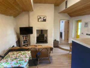 a living room with a table and a tv at The Thatched Cottage in Cork