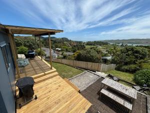 a wooden deck on the side of a house at Rakaunui Retreat in Raglan