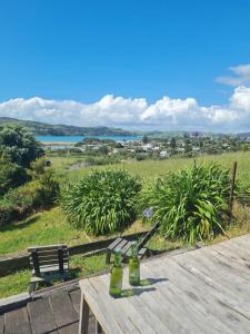 a picnic table with two bottles on top of it at Rakaunui Retreat in Raglan +4 photos