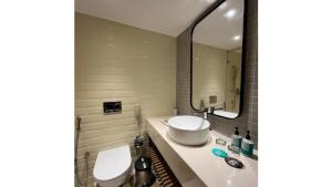 a bathroom with a sink and a toilet and a mirror at Greenpark Hyderabad in Hyderabad