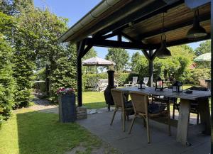 eine Terrasse mit Tisch und Stühlen unter einer Markise in der Unterkunft B&B Maarle in Poppel