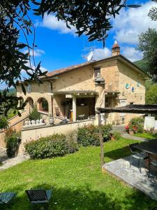 a large stone building with a yard with a table at Casa Del Sole in Camaiore