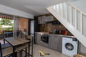 a kitchen with a table and a washing machine at Cozy duplexterrace barbecue pool beach on foot in Le Pradet